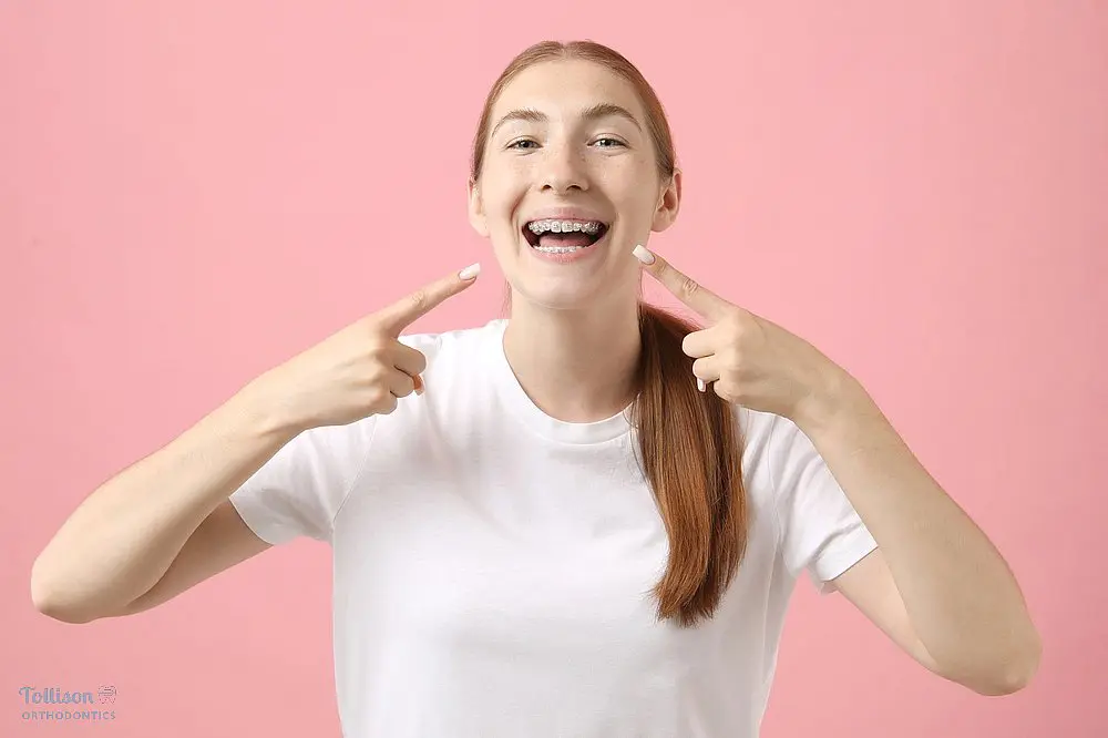 girl pointing at her metal braces after understanding how long do braces take in greenville, sc