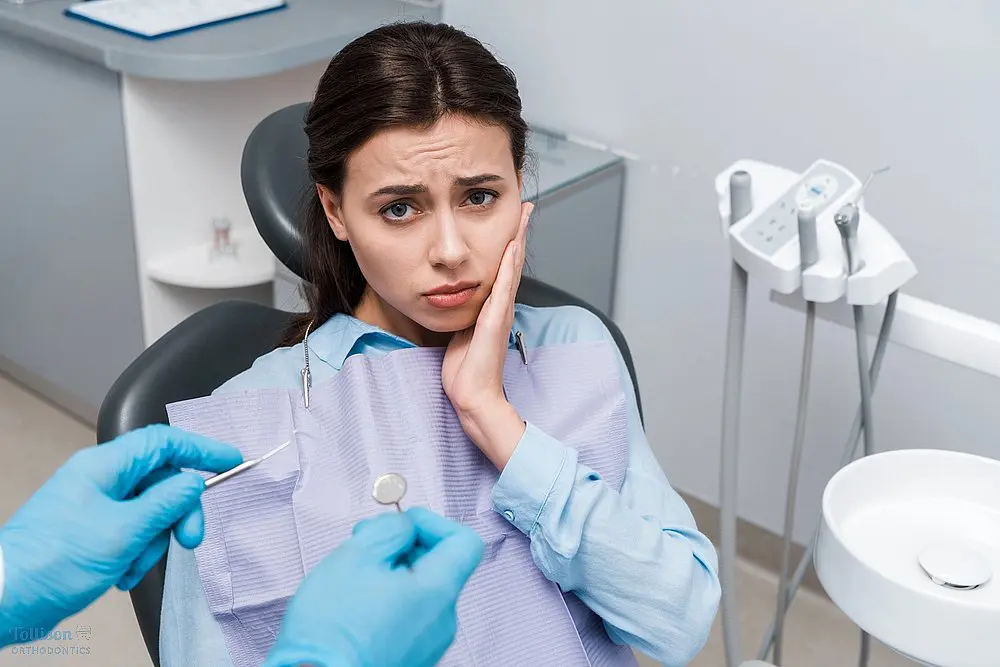 selective focus dentist latex gloves holding dental instruments upset woman - TMJ Treatment in Greenville, SC 